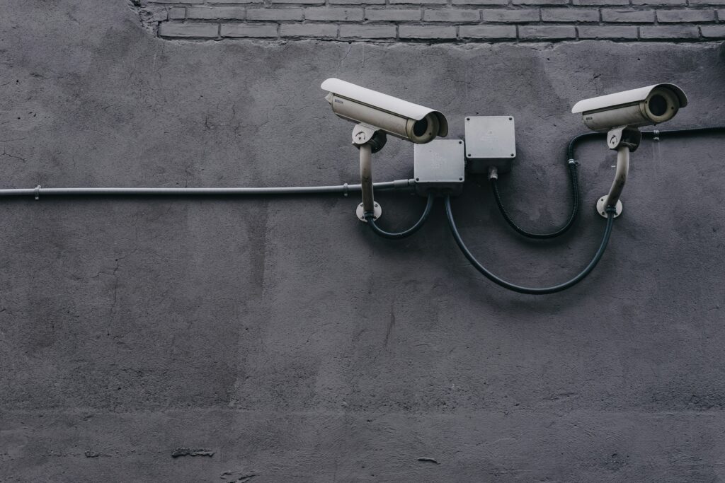 Security cameras mounted on a wall representing vigilance and monitoring