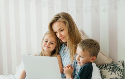 Mother with two children using a laptop together at home