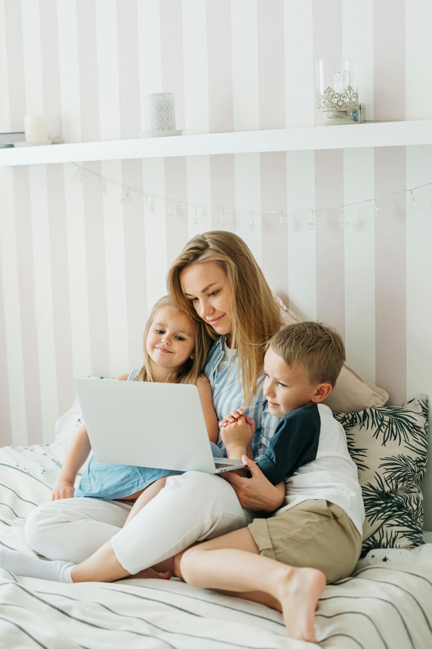 Mother with two children using a laptop together at home