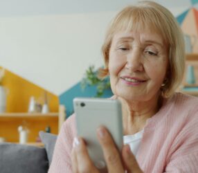 Smiling senior woman using smartphone for Florida's free government phone program